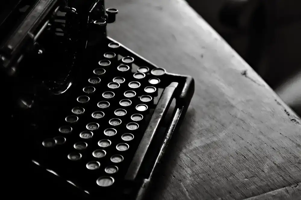 Vintage black typewriter resting on a wooden desk